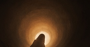 Silueta caminant cap a un túnel il·luminat