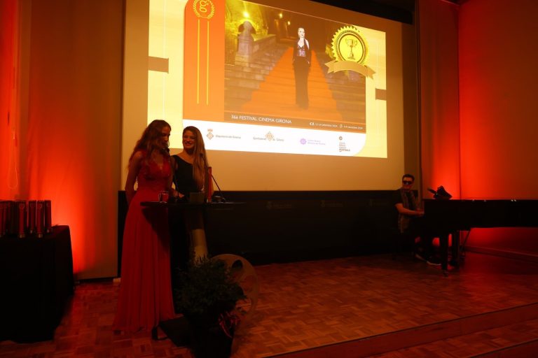 Dues presentadores a l’escenari de la gala, amb el cartell del festival a la pantalla