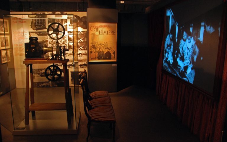 Sala del Museu del Cinema amb un projector antic i una pantalla